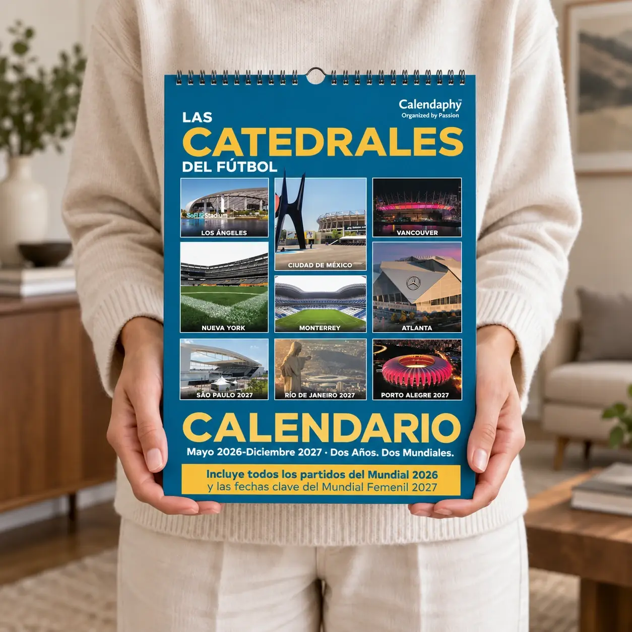 A person holding the Calendaphy "Cathedrals of Football" wall calendar.